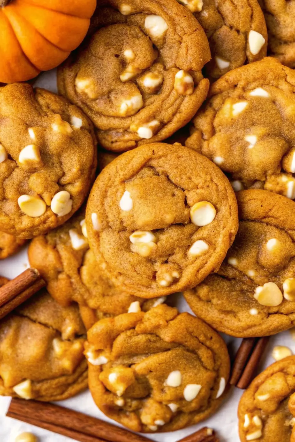 Chewy Pumpkin White Chocolate Chip Cookies stacked on a wooden board, natural light, best fall dessert recipe.